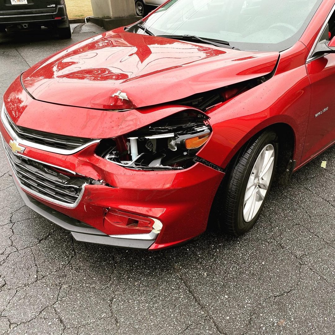Red Chevrolet front-end damage before repair